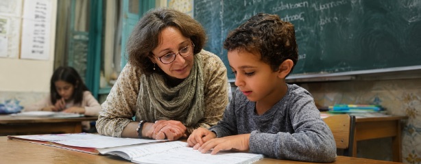 Bénévole aidant un enfant à faire ses devoirs